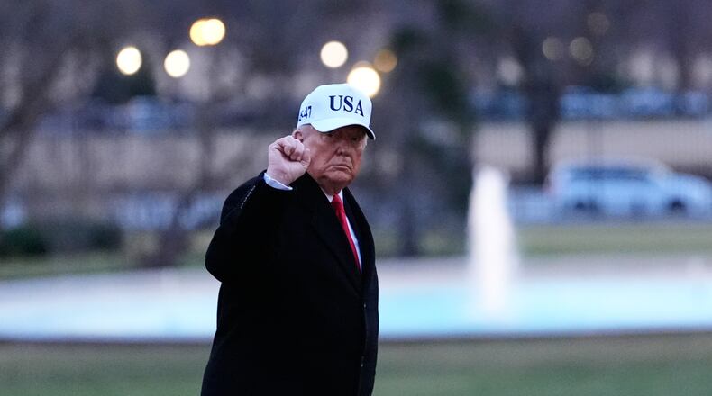 President Donald Trump gestures as he walks from Marine One after arriving on the South Lawn of the White House, Tuesday, Jan. 13, 2026, in Washington. (AP Photo/Alex Brandon)