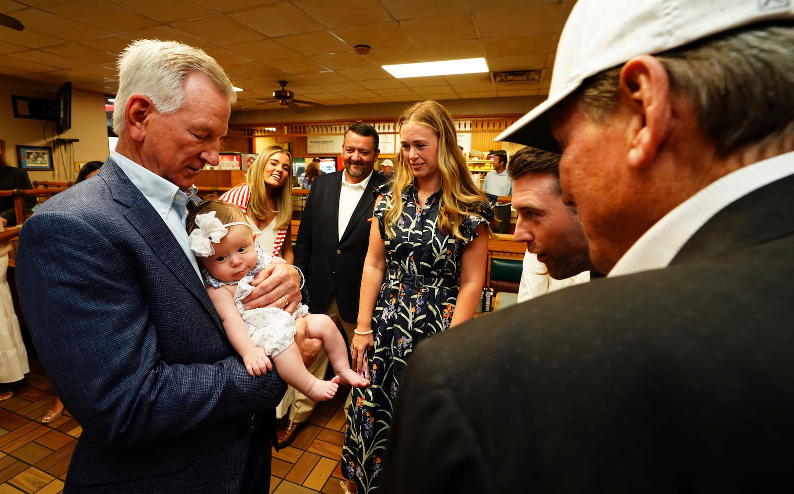 U.S. Sen. Tommy Tuberville, R-Ala., holds his granddaughter Rosie Grace Tuberville after he announced his plans to run for the governor of Alabama in 2026, Tuesday May 27, 2025 at Byron's Smokehouse in Auburn, Ala. (AP Photo/ John David Mercer)