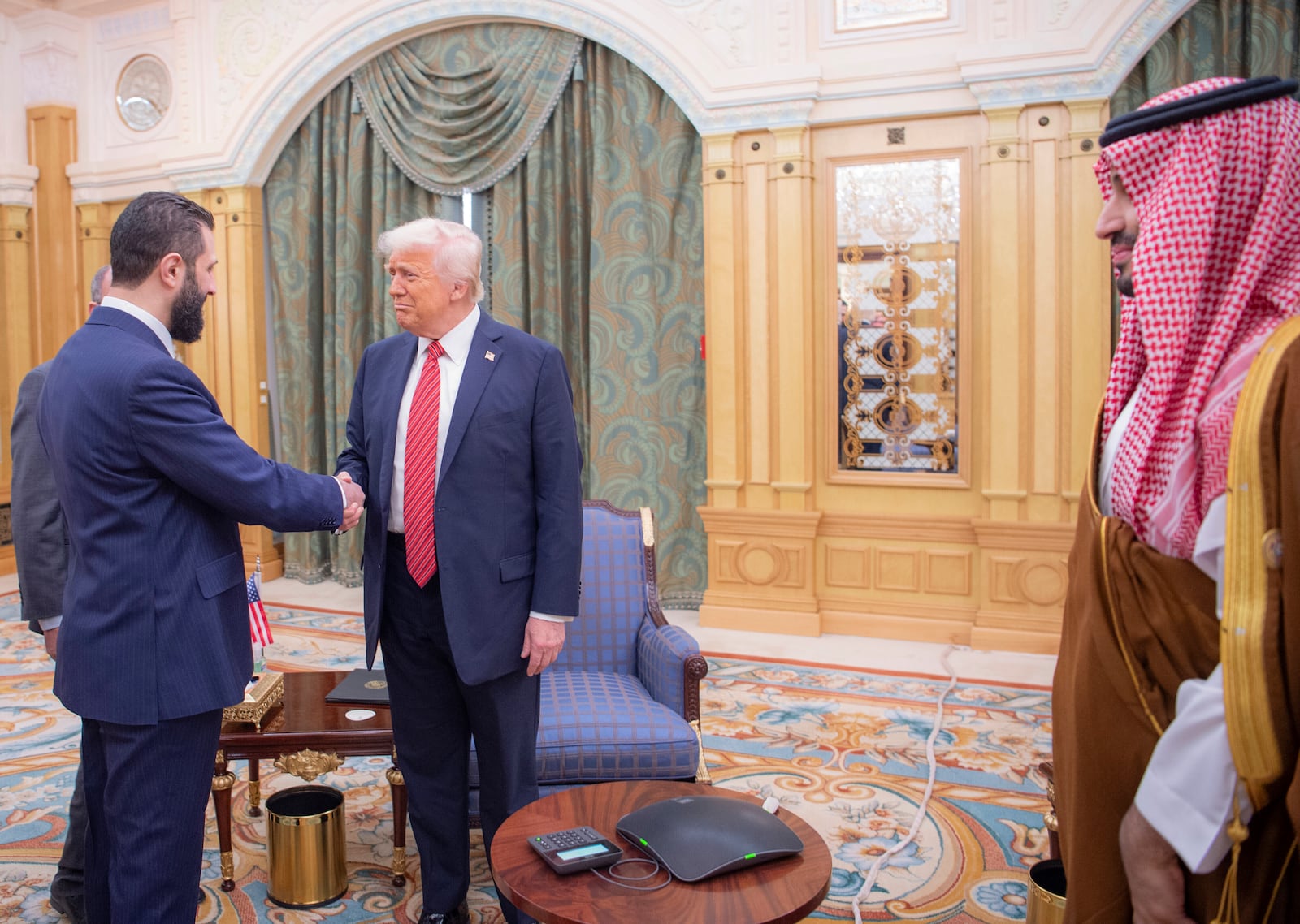 In this photo released by the Saudi Royal Palace, Syria's interim President Ahmad al-Sharaa, left, shakes hands with President Donald Trump, centre, in Riyadh, Saudi Arabia, Wednesday, May 14, 2025. At right is Saudi Crown Prince Mohammed bin Salman.(Bandar Aljaloud/Saudi Royal Palace via AP)