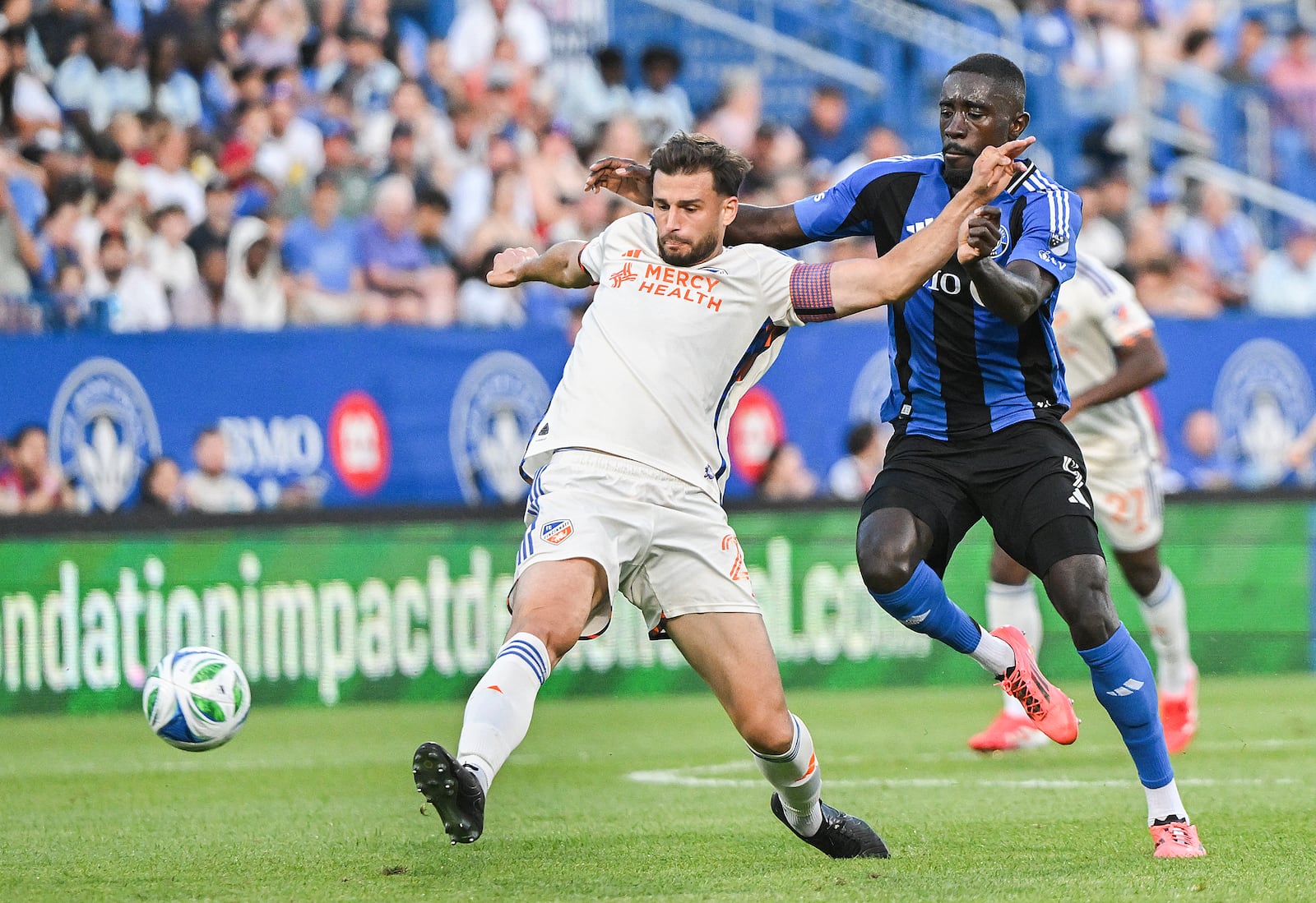 CF Montreal's Prince Owusu, right, challenges FC Cincinnati's Matt Miazga (21) during the first half of an MLS soccer match in Montreal, Wednesday, June 25, 2025. (Graham Hughes/The Canadian Press via AP)