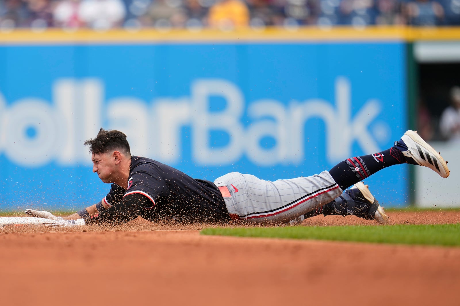 Minnesota Twins' Brooks Lee slides into second base with a double in the second inning of a baseball game against the Cleveland Guardians in Cleveland, Thursday, May 1, 2025. (AP Photo/Sue Ogrocki)