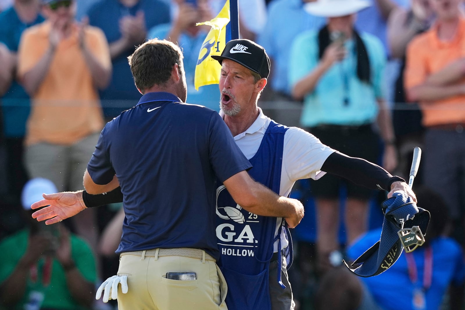Scottie Scheffler hugs his caddie Ted Scott after winning the PGA Championship golf tournament at the Quail Hollow Club, Sunday, May 18, 2025, in Charlotte, N.C. (AP Photo/David J. Phillip)