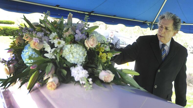 Funeral Home owner Larry Glickler places flowers on a casket at a recent funeral. MARSHALL GORBYSTAFF