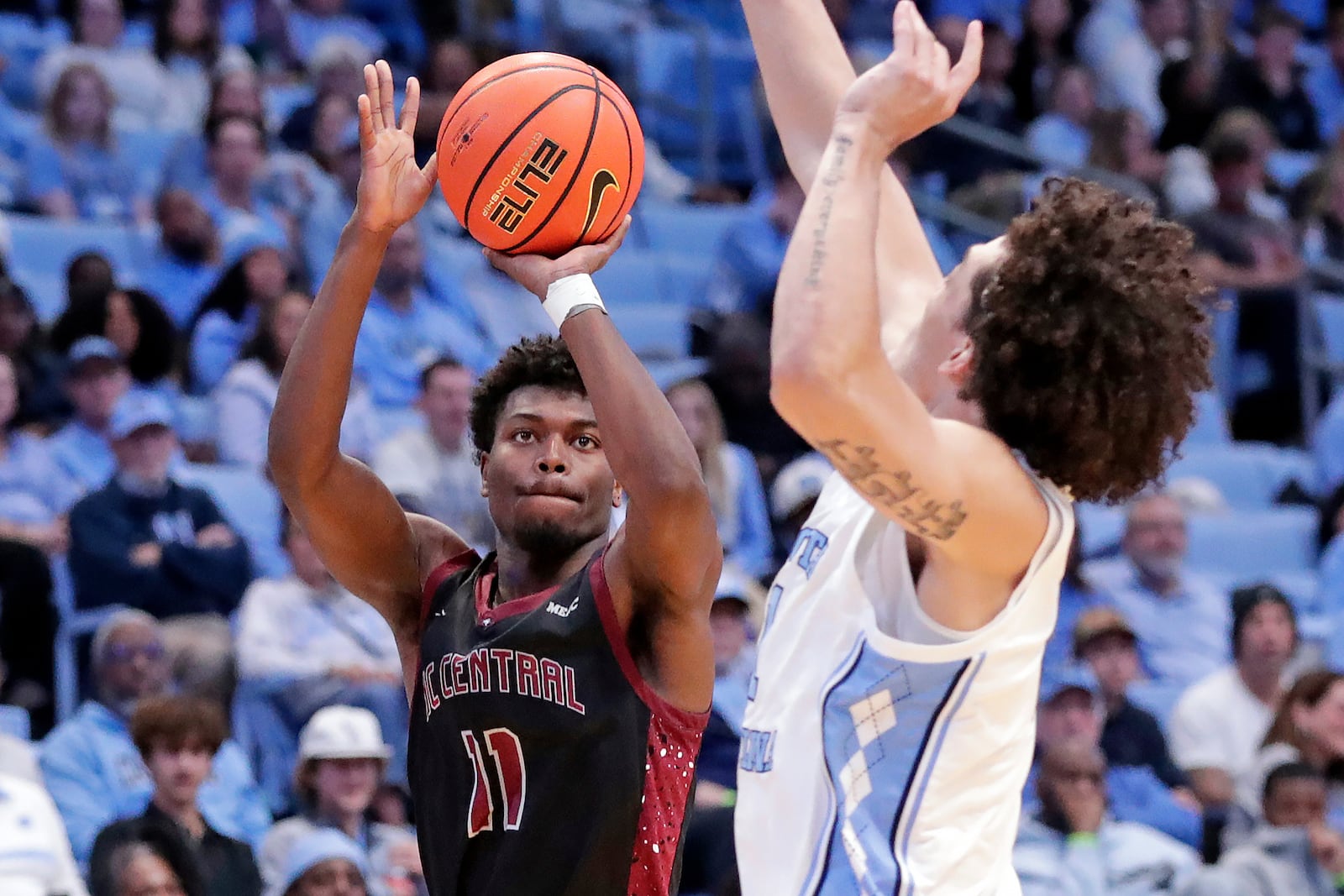 North Carolina Central guard Gage Lattimore (11) shoots as North Carolina forward Zayden High, right, defends during the second half of an NCAA college basketball game Friday, Nov. 14, 2025, in Chapel Hill, N.C. (AP Photo/Chris Seward)