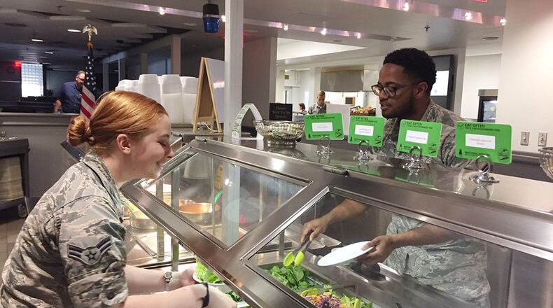 A popular choice at Pitsenbarger Dining Hall is the ‘pure food’ salad bar, which offers 26 items, including whole grain-based specialty salads like barley and quinoa, made from scratch on-site. Airmen 1st Class Abbigael Roberts and Gregory Miller, both medical laboratory technicians in the specimen collection laboratory, Wright-Patterson Medical Center, visit the salad bar on July 3. (Skywrighter photo/Amy Rollins)