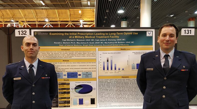 Capt. Micheal Massoud (left), stands with research associate Capt. James Dizmang in front of the poster highlighting patient-oriented research that earned Massoud an award in the annual American College of Physicians abstract and poster competition. (Courtesy photo)