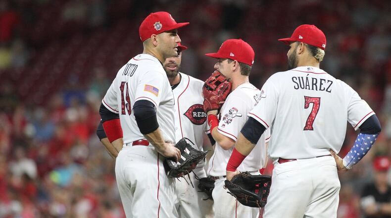 Reds infielders (left to right) Joey Votto, Jose Peraza, Scooter Gennett and Eugenio Suarez gather during a game against the White Sox on July 2, 2018, at Great American Ball Park in Cincinnati. David Jablonski/Staff