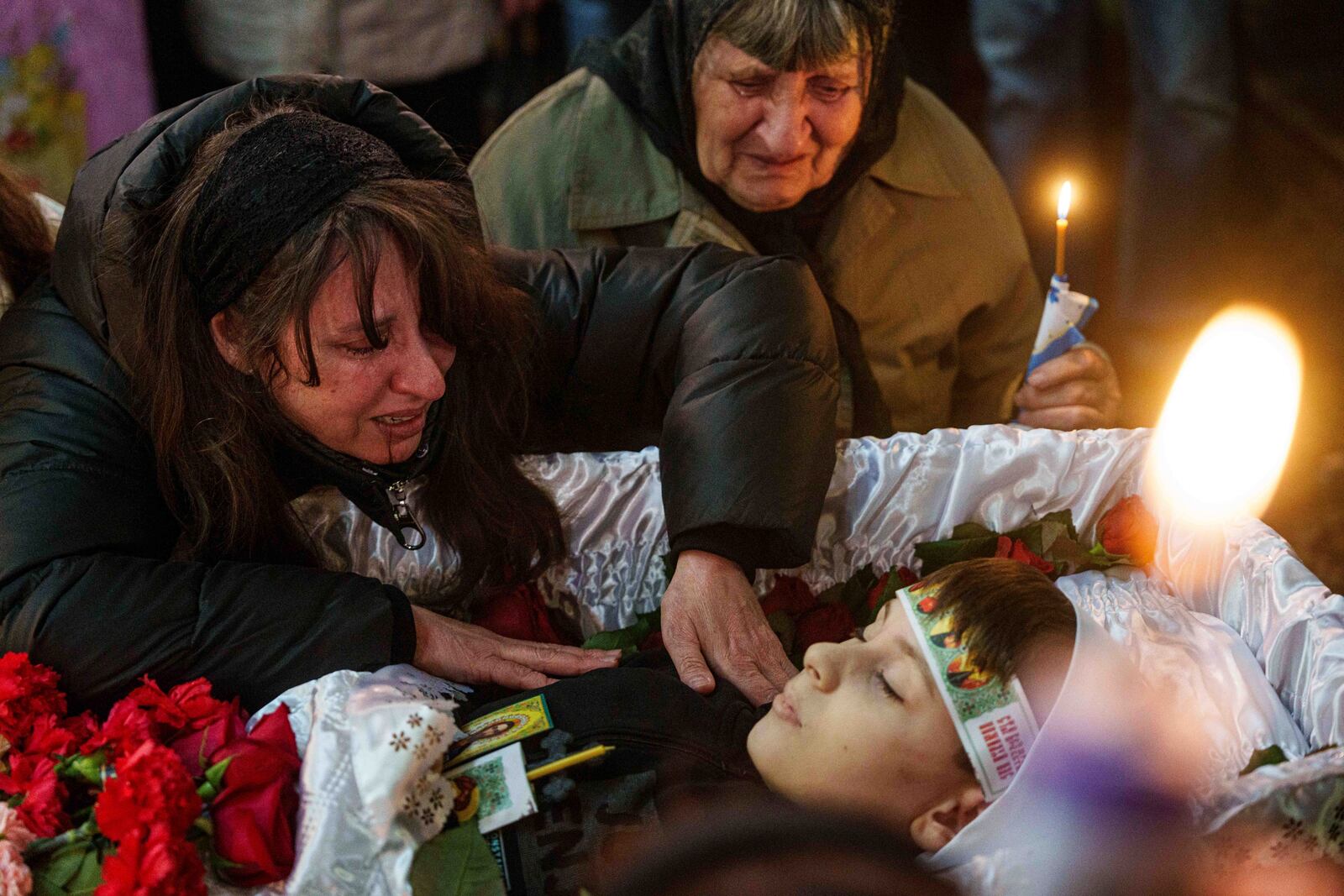 A mother cries at the coffin of her son Herman Tripolets, 9, killed by a Russian missile, during a funeral ceremony in Kryvyi Rih, Ukraine, Monday, April 7, 2025. (AP Photo/Evgeniy Maloletka)