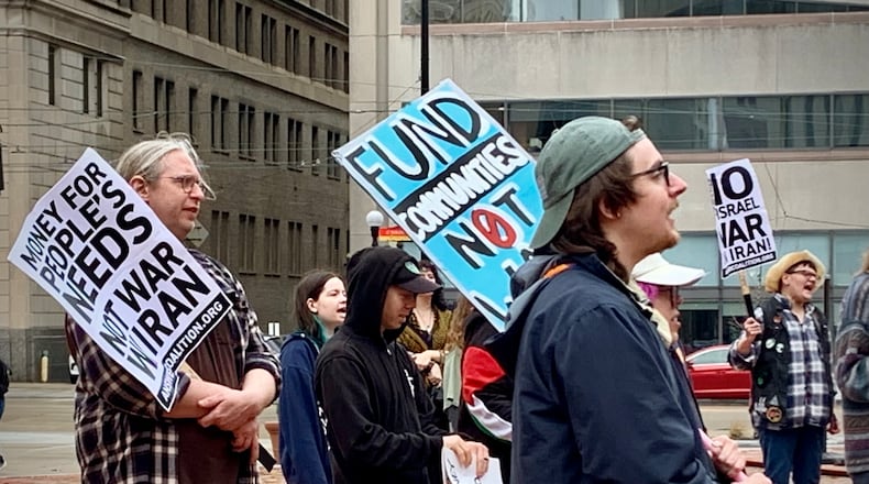 Daytonians gathered at Courthouse Square in the rain Saturday to protest ongoing US involvement in the war with Iran. LONDON BISHOP/STAFF