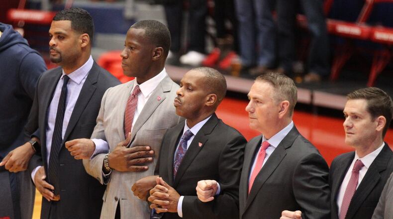 Dayton coaches, including Anthony Grant, second from left, stand for the national anthem before a game against North Florida on Wednesday, Nov. 7, 2018, at UD Arena. David Jablonski/Staff