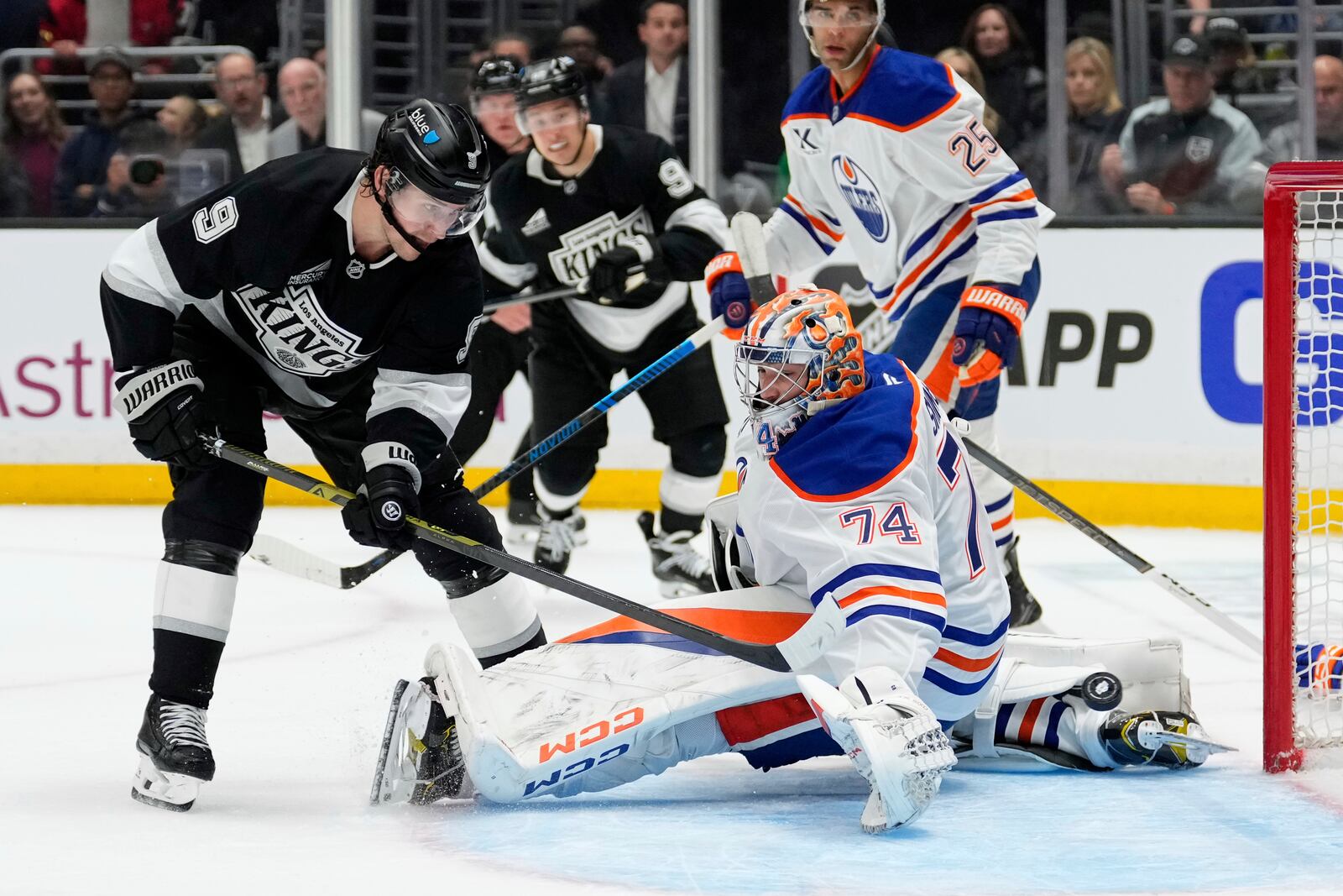 Los Angeles Kings right wing Adrian Kempe, left, scores on Edmonton Oilers goaltender Stuart Skinner during the second period in Game 1 of an NHL hockey first-round playoff series Monday, April 21, 2025, in Los Angeles. (AP Photo/Mark J. Terrill)