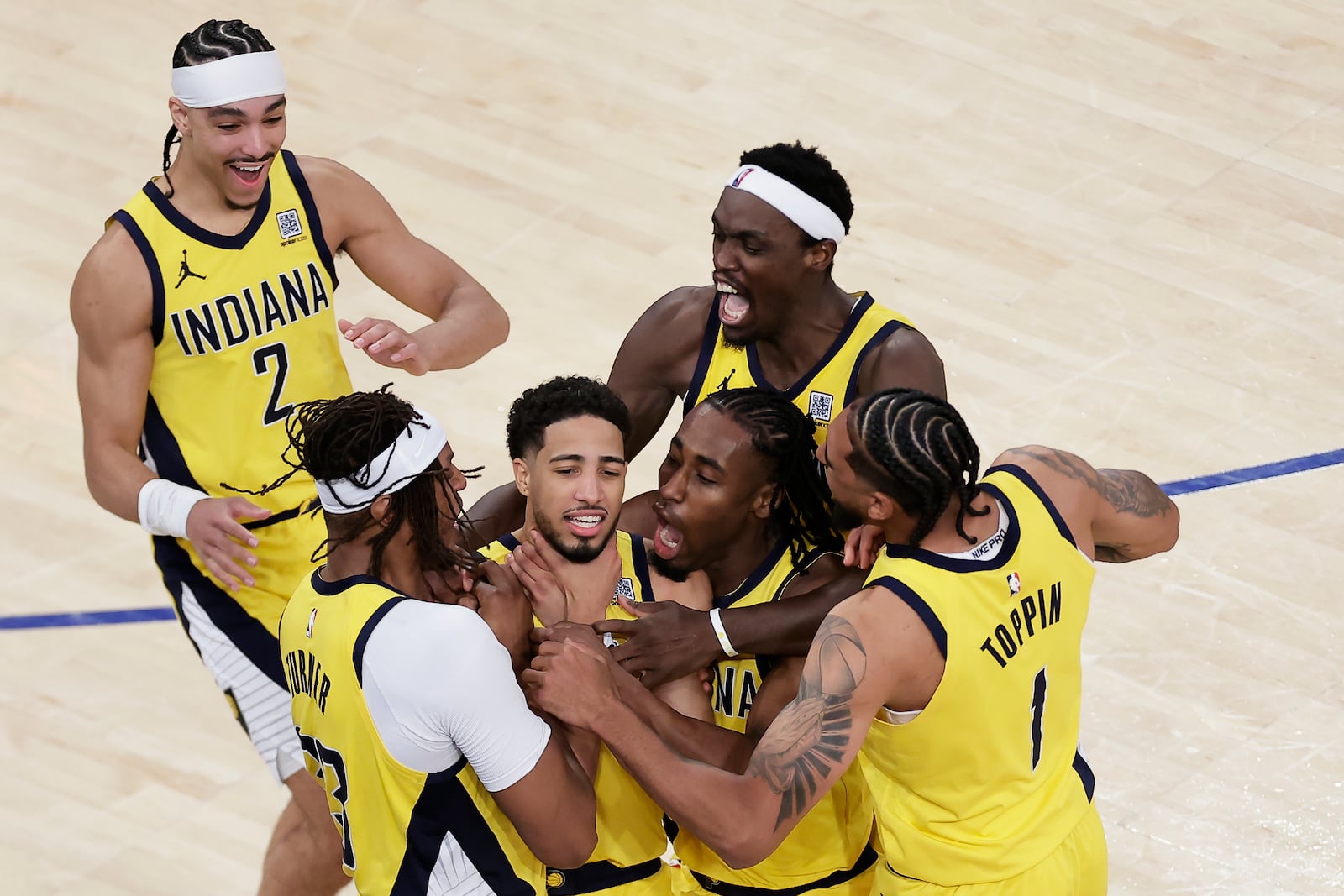 Indiana Pacers guard Tyrese Haliburton (0) is mobbed by teammates as he makes a choking motion after hitting a shot against the New York Knicks at the end of regulation to tie Game 1 of the NBA basketball Eastern Conference final, Wednesday, May 21, 2025, in New York. (AP Photo/Adam Hunger)