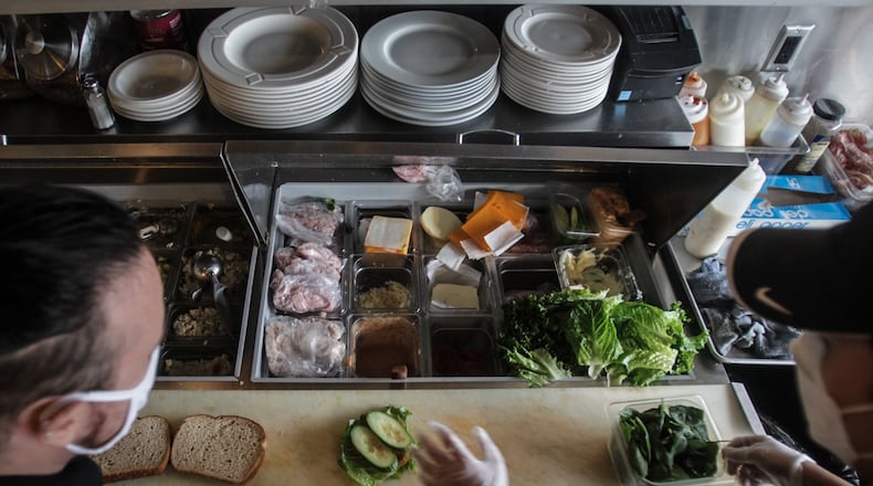 Alexei Ware, left and Paul Lee make a sandwich at Flyboys Deli on Far Hills in Oakwood Tuesday January 12, 2021. Restaurant commodities prices have increased during COVID-19, anything from kitchen gloves, deli meat and veggies. JIM NOELKER/STAFF