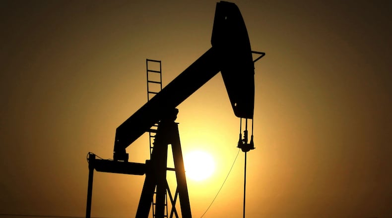 FILE- In this Wednesday, June 8, 2011 file photo, sun sets behind an oil pump in the desert oil fields of Sakhir, Bahrain. (AP Photo/Hasan Jamali, File)