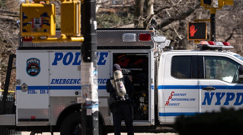 An NYPD officer carrying a oxygen tank stands outside Carl Schurz Park as they investigate suspicious device, Tuesday, March 10, 2026, in New York. (AP Photo/Yuki Iwamura)