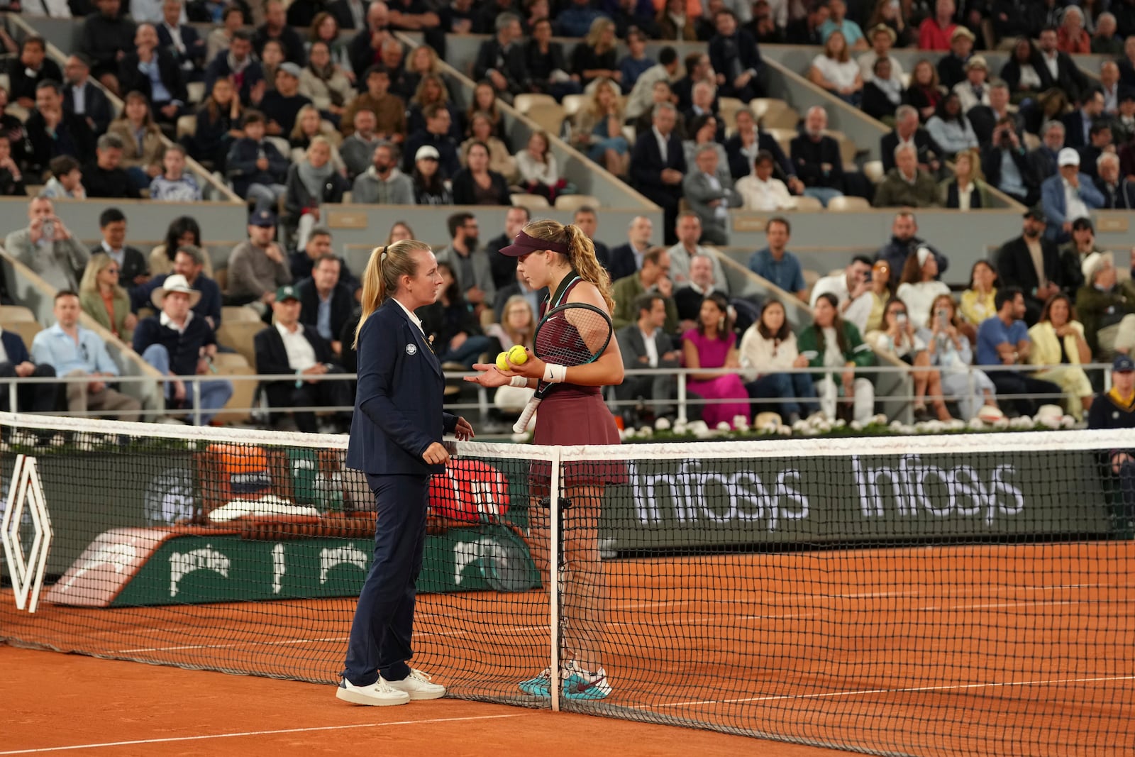 Russia's Mirra Andreeva, right, speaks with umpire Miriam Bley during the quarterfinal match of the French Tennis Open against France's Lois Boisson at the Roland-Garros stadium in Paris, Wednesday, June 4, 2025. (AP Photo/Aurelien Morissard)