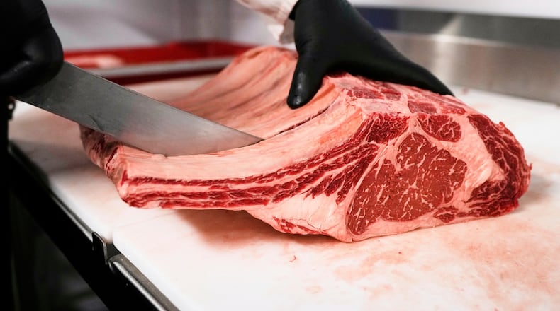 FILE - Raul Rubero, lead butcher at Deep Cuts butcher shop cuts single portions of bone-in steaks as he breaks down a side of beef, Wednesday, Aug. 27, 2025, in Dallas. (AP Photo/Tony Gutierrez, File)