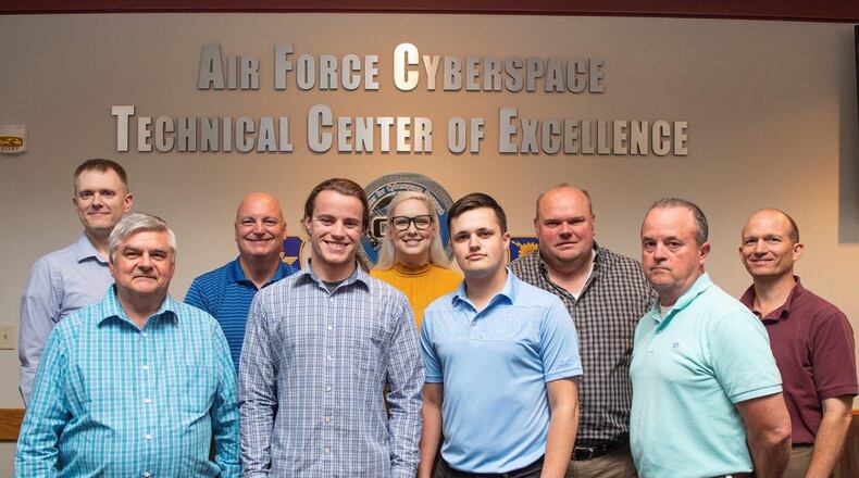 Air Force Institute of Technology Assistant Professor of Cyber Systems Mark Reith (back left), Matthew Dever (second from right), Air Force Cyberspace Technical Center of Excellence, assistant to the director, and other team members created a cloud-based educational hub as a research project to improve user motivation and engagement with training. (U.S. Air Force photo/Wesley Farnsworth)