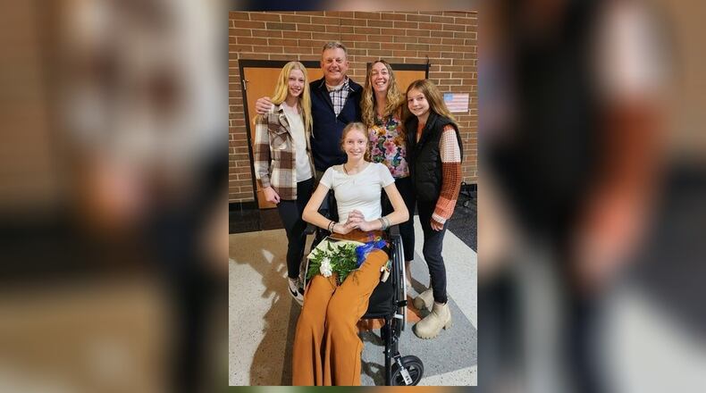 This past Monday – two days after coming home from the hospital following her near fatal accident with a tractor trailer in September – Brooke Bergman was inducted into the National Honor Society at Versailles High. After rolling herself across the stage in her wheelchair to get her certificate, she posed with her family (left to right): her sister Allison; her dad Kevin, mom Gwen and sister Claire. CONTRIBUTED
