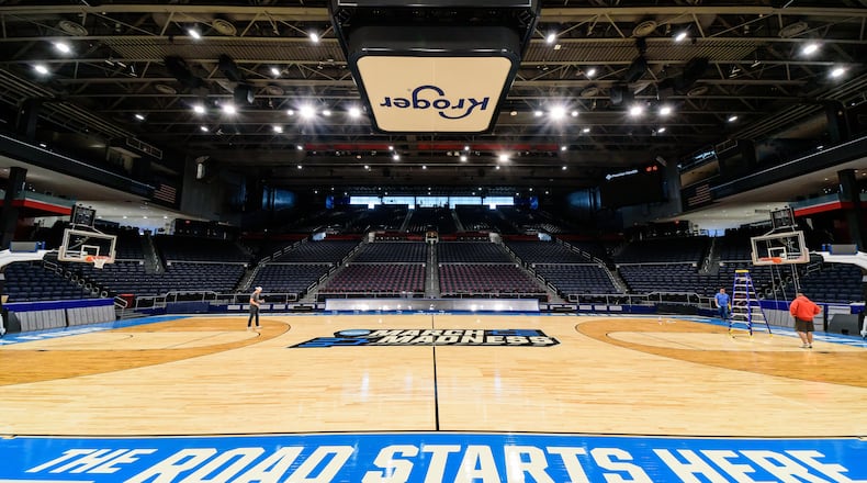 On St. Patrick's Day 2024, workers put the finishing touches on the basketball court installation for the First Four of the NCAA Division I Men’s Basketball Championship at UD Arena which will take place on March 19 & 20, 2024. TOM GILLIAM / CONTRIBUTING PHOTOGRAPHER