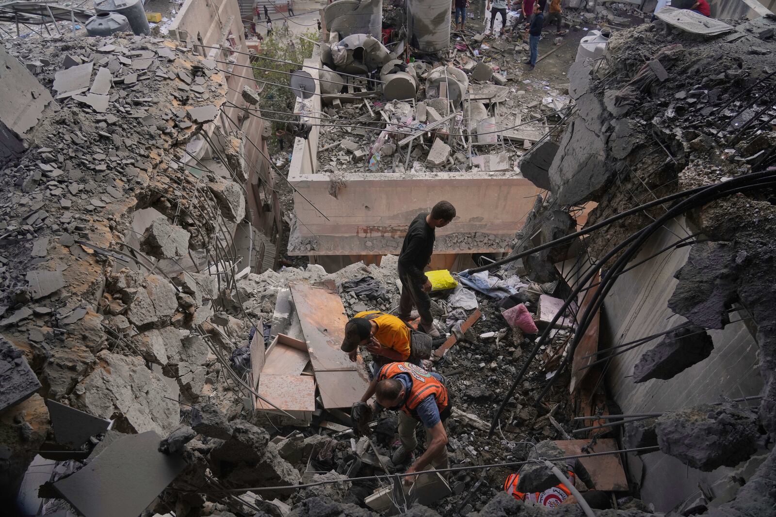 Palestinian men search through the debris following an Israeli airstrike on a residential building in Gaza City, Thursday, April 24, 2025. (AP Photo/Jehad Alshrafi)