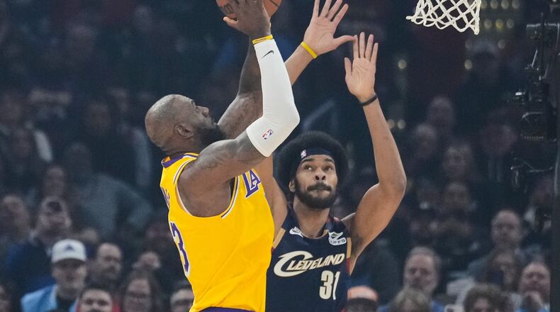 Los Angeles Lakers forward LeBron James left, shoots over Cleveland Cavaliers center Jarrett Allen (31) in the first half of an NBA basketball game in Cleveland, Wednesday, Jan. 28, 2026. (AP Photo/Sue Ogrocki)