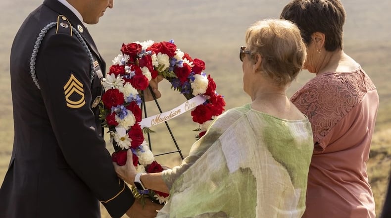 A member of the Wyoming Army National Guard helps the family of the lost crew present a wreath at the memorial service for the crew of Consolidated B-24J Liberator number 42-95559 outside of Casper, Wyo., July 24, 2021. (U.S. Army National Guard photo by Sgt. Stew Dyer)