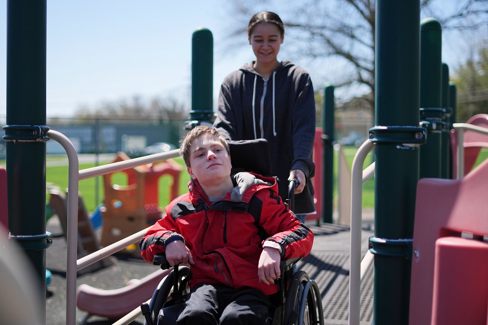 Fischer, accompanied by paraprofessional Olivia Lilliston rides on a playground ramp at Archbishop Damiano School in Westville, N.J., Wednesday, April 9, 2025. (AP Photo/Matt Rourke)