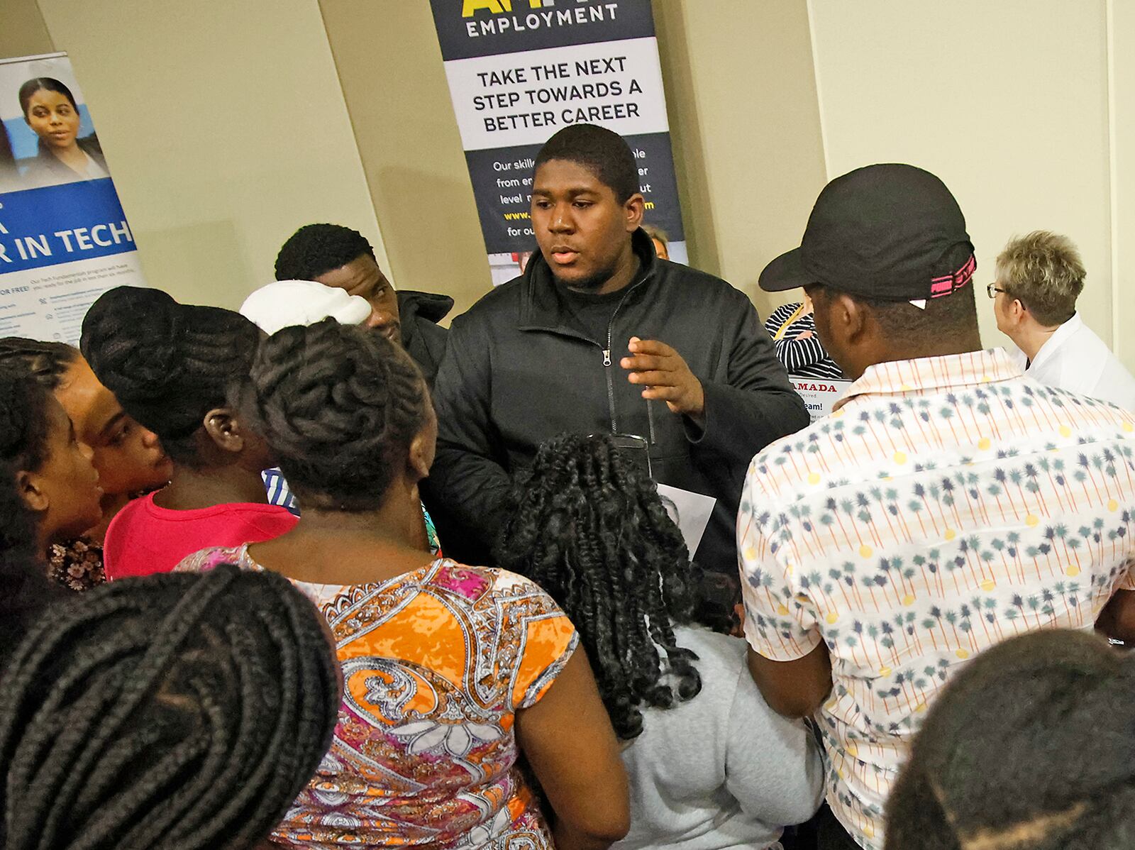 Members of Springfield's Haitian community gather around Bradley Jean, center, as he translates for them at the 14th Annual Clark County Job Fair Wednesday, April 17, 2024. The job fair featured 60 employers looking for skilled and unskilled workers.  BILL LACKEY/STAFF