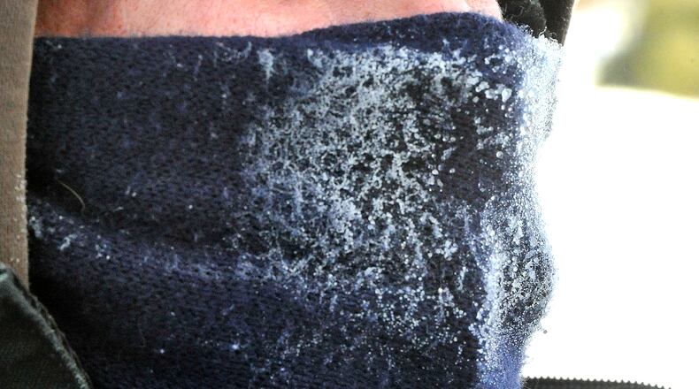 The scarf covering Craig Falke's face is covered with ice as the moisture in his breath freezes while he works outside. Bill Lackey/Staff