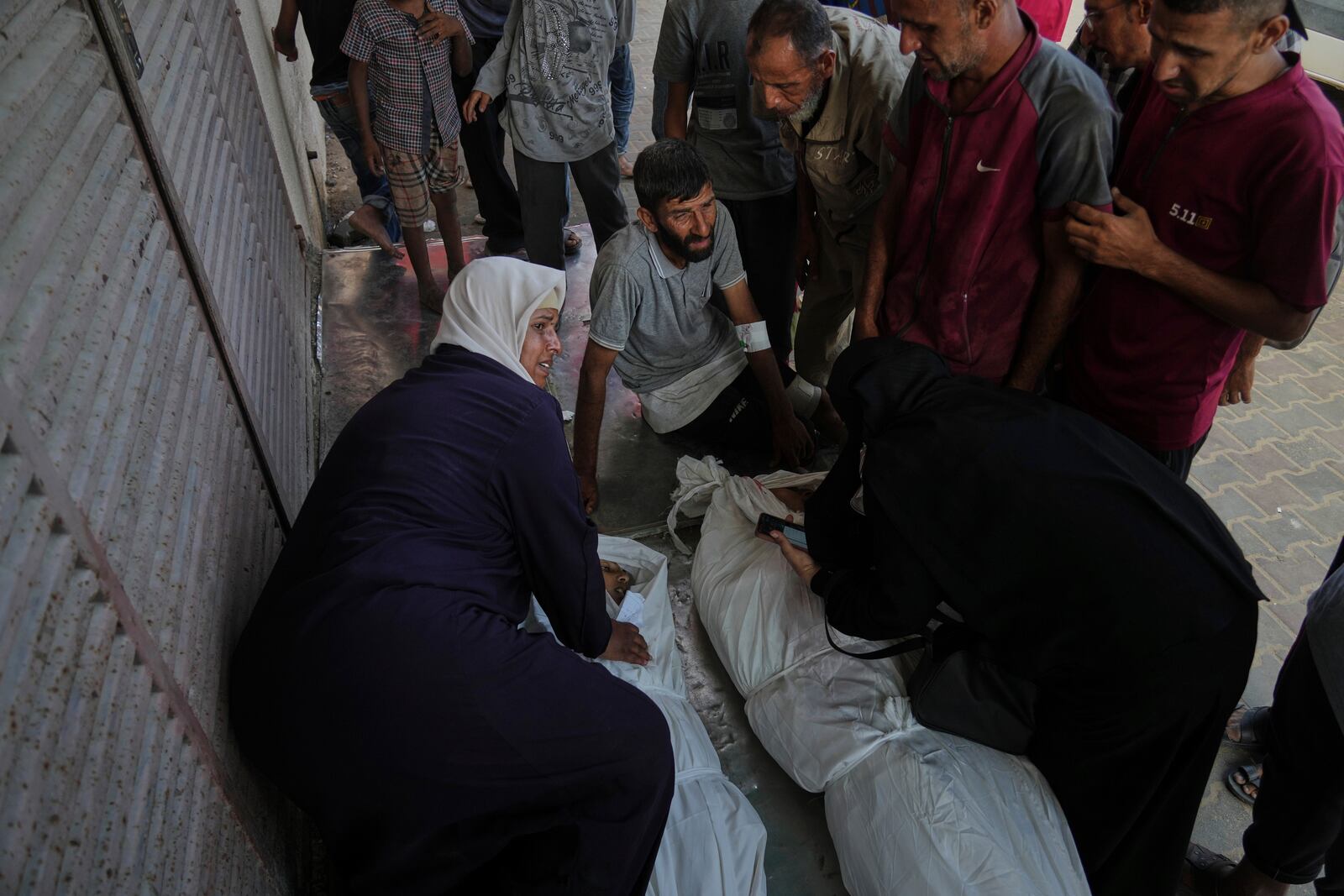 Mourners attend the funeral of their relatives killed in an Israeli bombardment, in Deir al-Balah, central Gaza Strip, Monday, July 21, 2025. (AP Photo/Abdel Kareem Hana)