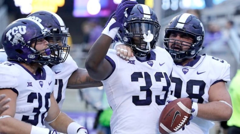 TCU running back Sewo Olonilua (33) celebrates with teammates after scoring a touchdown during the second half of an NCAA college football game against Kansas State Saturday, Oct. 14, 2017, in Manhattan, Kan. TCU won 26-6. After two weather delays, the game ended 7 hours and 15 minutes after the scheduled start time. (AP Photo/Charlie Riedel)