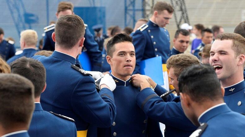 Cadets change their shoulder boards from cadet rank to second lieutenant rank at Falcon Stadium during the U.S. Air Force Academy Class of 2019 graduation ceremony in Colorado Springs, Colo., May 30. Nine-hundred-eighty-nine cadets crossed the stage to become the Air Force’s newest second lieutenants, a handful of which are now officers at Wright-Patterson Air Force Base. (U.S. Air Force photo/Darcie L. Ibidapo)