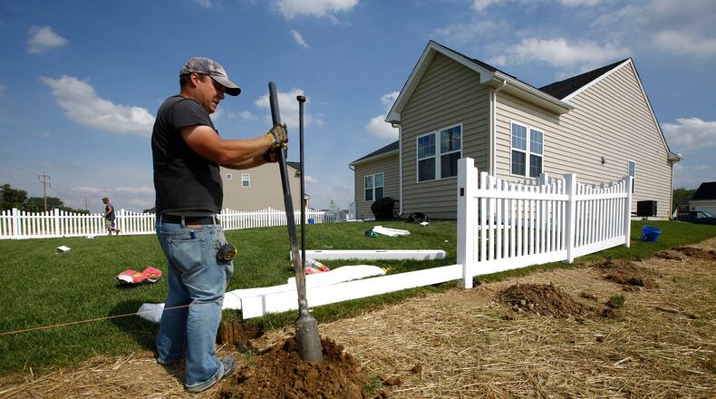 In this 2015 file photo, Luke Hogeland installs a fence at a new house in the Waterford Landing housing development in Fairborn. TY GREENLEES / STAFF