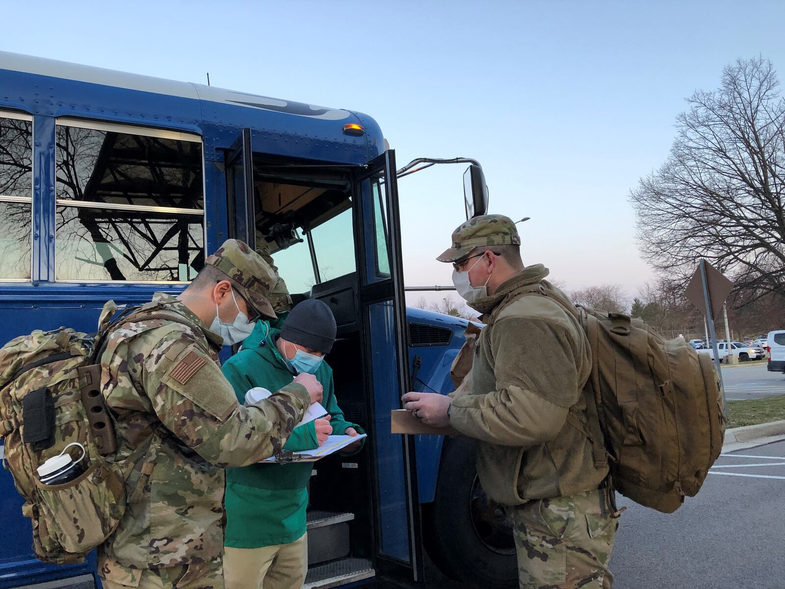 Airmen from Wright-Patterson get onto a bus early morning on Friday, March 19, 2021. They are deploying to Detroit to help with a mass vaccination effort. STAFF/BONNIE MEIBERS