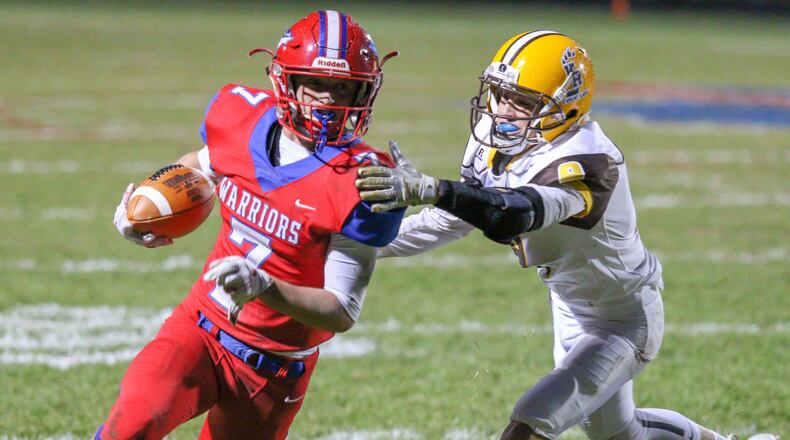 Northwestern High Schoolâs Eli Berner runs past Kenton Ridgeâs Drew Miller during their game at Taylor Field on Friday, Oct. 19. The Warriors won 21-14. MICHAEL COOPER/CONTRIBUTED