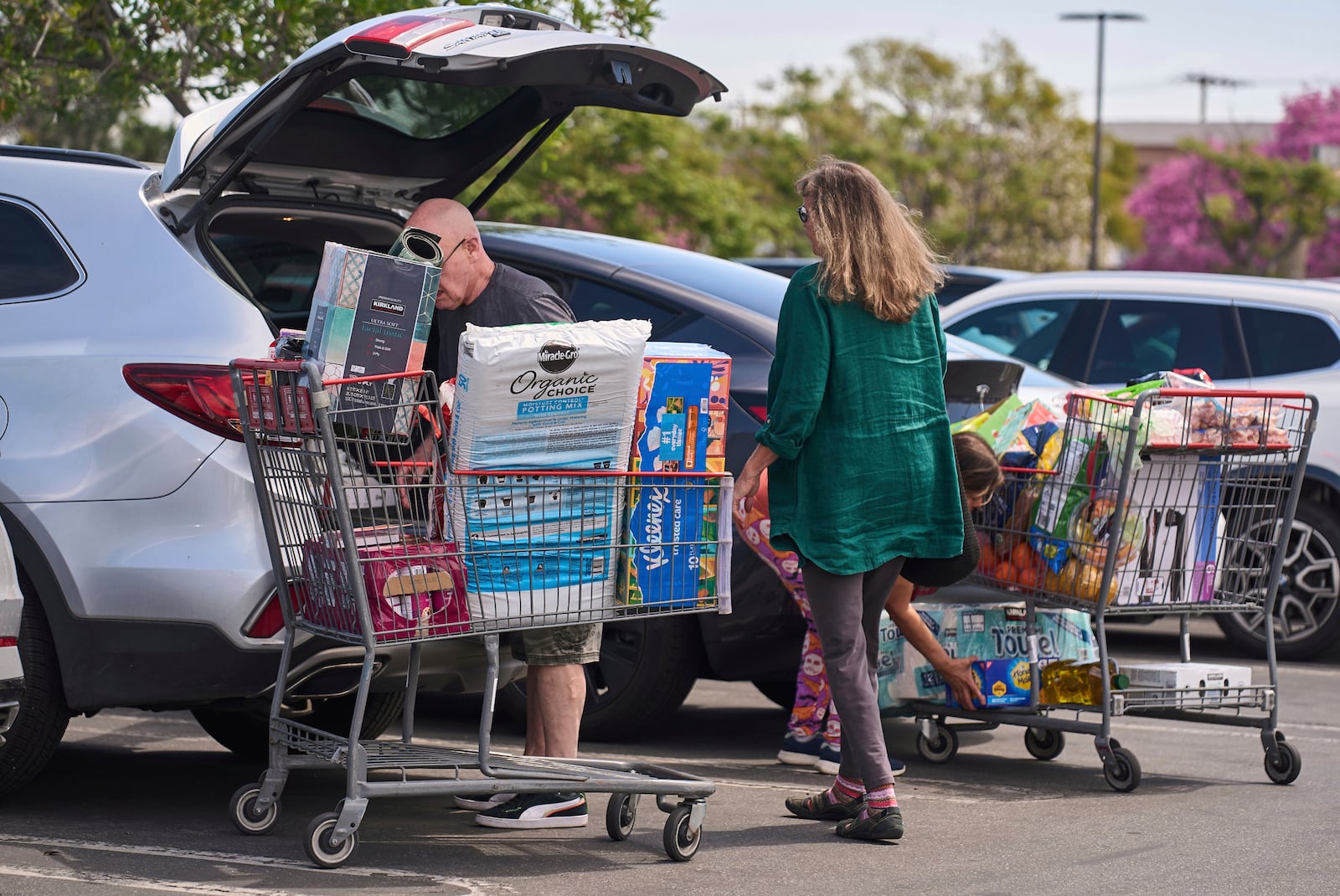 FILE - People pack their supplies into their vehicles at Costco Wholesale store in Burbank, Calif., on Thursday, April 10, 2025. (AP Photo/Damian Dovarganes, File)