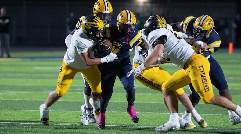 Centerville's defense, led by Landon King (left) and Mason Keely (right) bring down Springfield running back Deontre Long Friday night at Springfield. Logan Howard/CONTRIBUTED