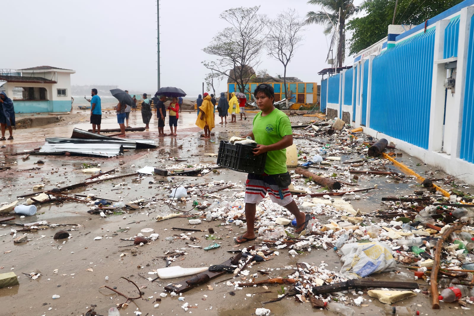 A walks through debris after Hurricane Erick hit near Puerto Escondido, Oaxaca state, Mexico, Thursday, June 19, 2025. (AP Photo/Luis Alberto Cruz)