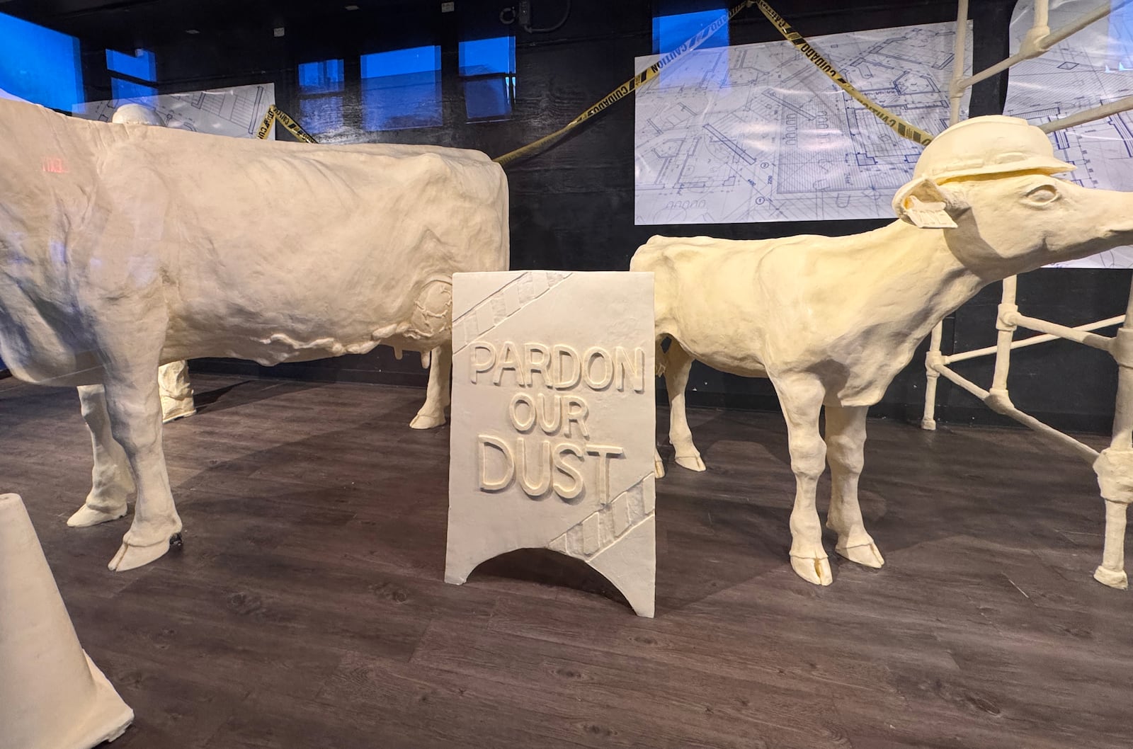 The 2025 butter cow display at the Ohio State Fair asks fairgoers to “Pardon Our Dust!” Major renovations are underway across the fairgrounds, including in the historic Dairy Products Building, the home of the butter cow and calf.