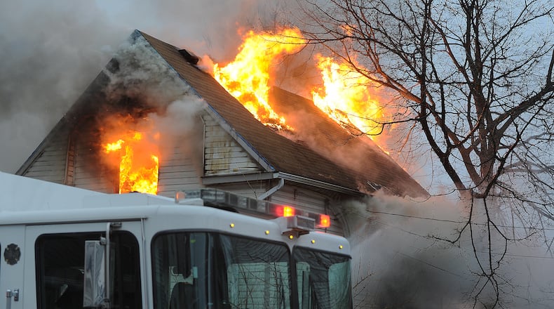 One person is custody in connection to a house fire in the 2600 block of East Second Street of Dayton on Monday morning. Two people jumped out of the window of the burning home. Dayton Fire Department Chief Jeff Lykins said that the fire is believed to be arson. MARSHALL GORBY/STAFF