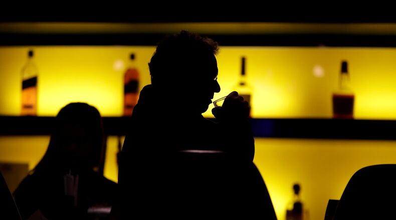 In this 2017 photo, a patron sips his drink while having a meal at a bar. More government data points to alcohol's role in U.S deaths during the pandemic. (AP Photo/Julio Cortez, File)