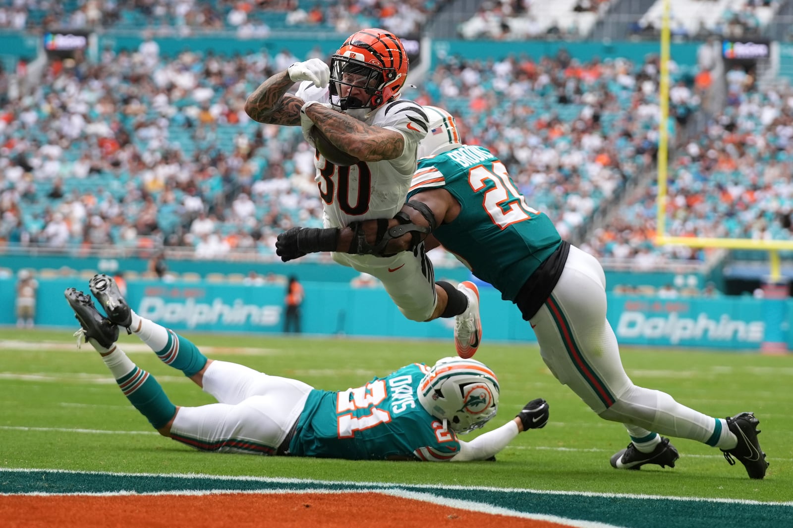 FILE - Cincinnati Bengals running back Chase Brown (30) breaks a tackle by Miami Dolphins linebacker Jordyn Brooks (20) for a touchdown during the second half of an NFL football game Sunday, Dec. 21, 2025, in Miami Gardens, Fla. (AP Photo/Lynne Sladky, File)
