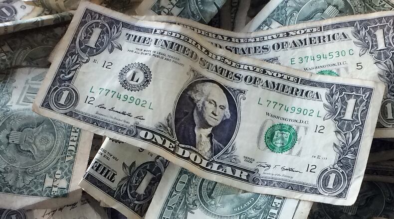 This Oct. 24, 2016, photo shows dollar bills in New York. Fraudsters are increasingly picking up the phone and trying to steal your money by pretending to be a government worker or a family member in trouble. In 2016, impostor scams overtook identity theft to become the second-most reported fraud, according to the U.S. Federal Trade Commission. (AP Photo/Mark Lennihan)