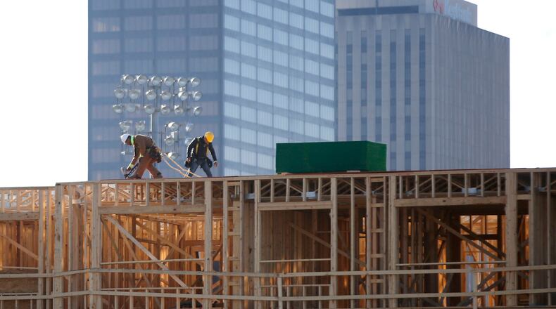 Workers build out the Centerfield Flats on East First Street next to Fifth Third Field in downtown Dayton. The 112 unit apartments are expected to open in the summer of 2019. TY GREENLEES / STAFF