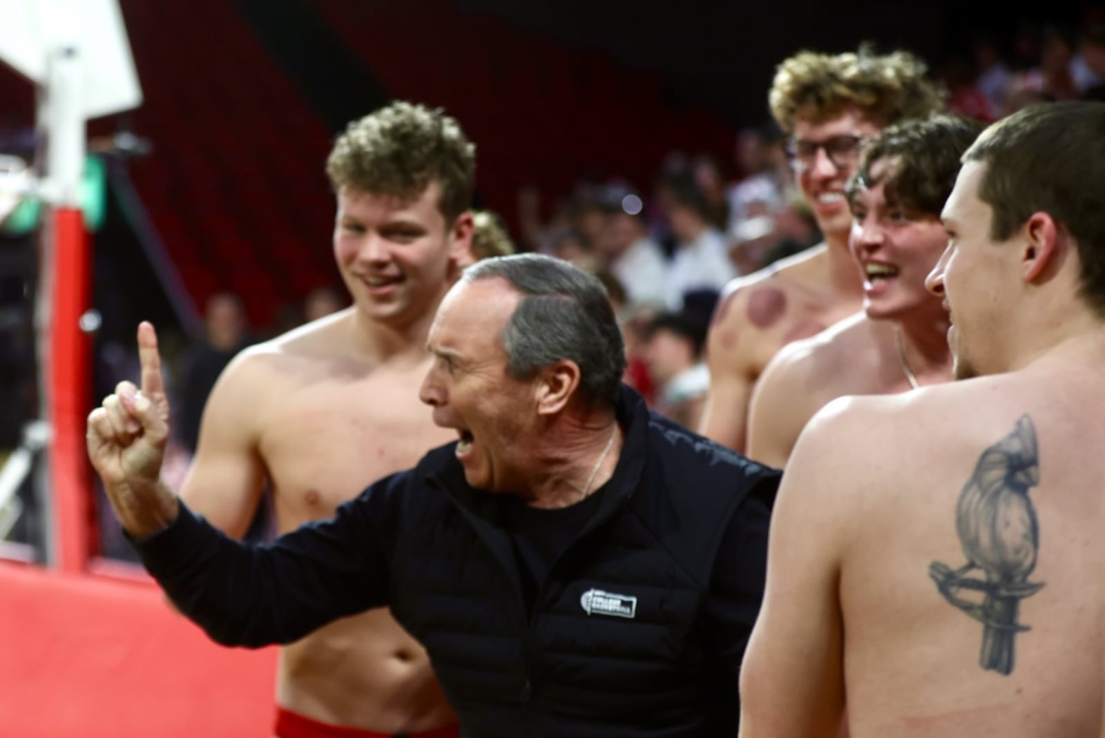Mark Adams poses for a photo with Miami swimmers before a men's basketball game at Millett Hall on Friday, Feb. 13, 2026, in Oxford. David Jablonski/Staff