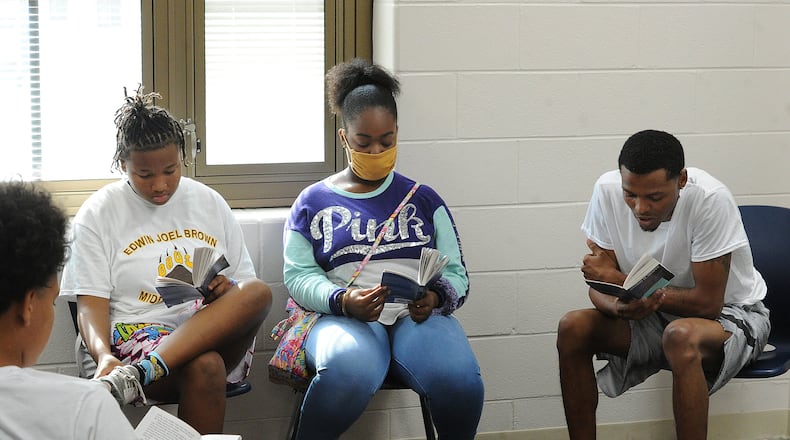 Students, from left, LaVonna Whatley and Shayla Davis, read with Servant Leader Intern, Terry Matthews III, during a DPS Summer Camp at Edwin Joel Brown Middle School. MARSHALL GORBY\STAFF