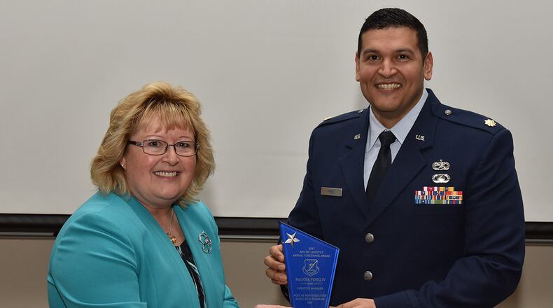 Cynthia Abbott, director of Logistics and Logistics Services, presents Maj. Jose Perez IV with a Logistics award. Perez was one of many individuals honored for outstanding achievement. (U.S. Air Force photo/Michelle Gigante)