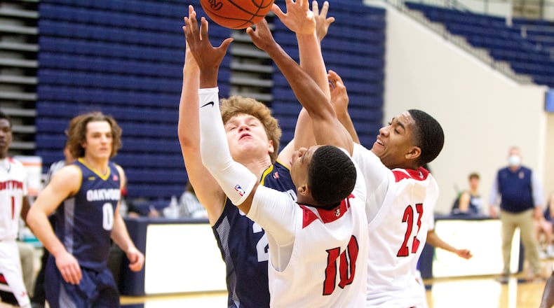 Oakwood's Will Maxwell and Trotwood-Madison's Anthnoy McComb (10) and Tim Carpenter battle for a rebound Friday night in their Division II district semifinal. Trotwood advanced to the district final with a 70-62 victory. Jeff Gilbert/CONTRIBUTED