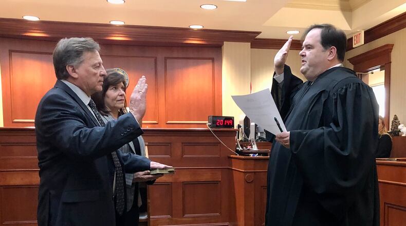 Joseph Statzer is sworn in as acting Butler County auditor Thursday, Dec. 29, 2022. He is seen here alongside his wife, Amy. At right is Judge John M. Holcomb of the Butler County Common Pleas Court, Probate Division. CONTRIBUTED
